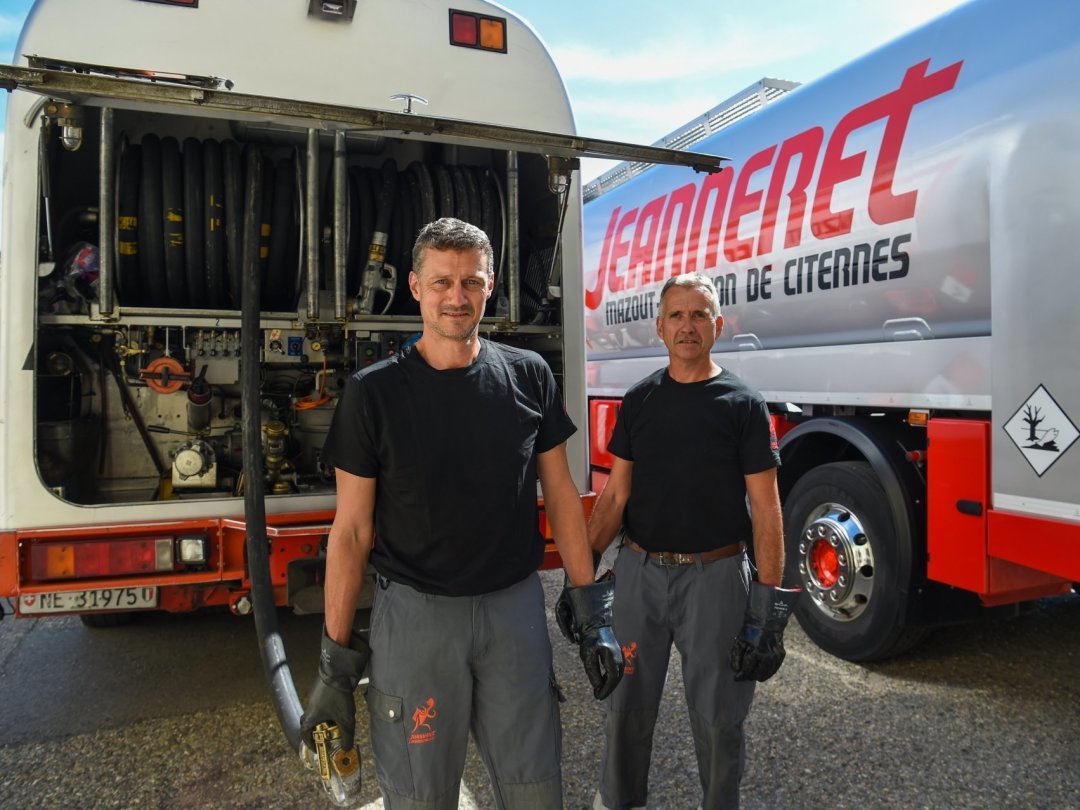 Pascal (à gauche) et Pierre-Alain Jeanneret posent devant les deux camions de la PME familiale installée à Peseux.